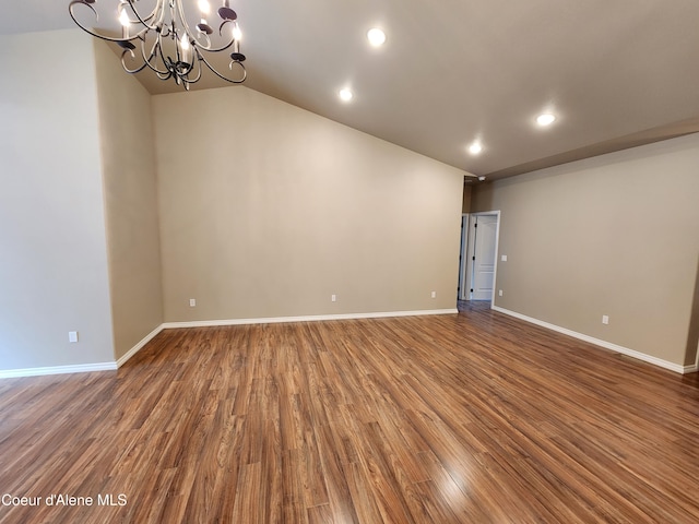 spare room with a notable chandelier and hardwood / wood-style flooring