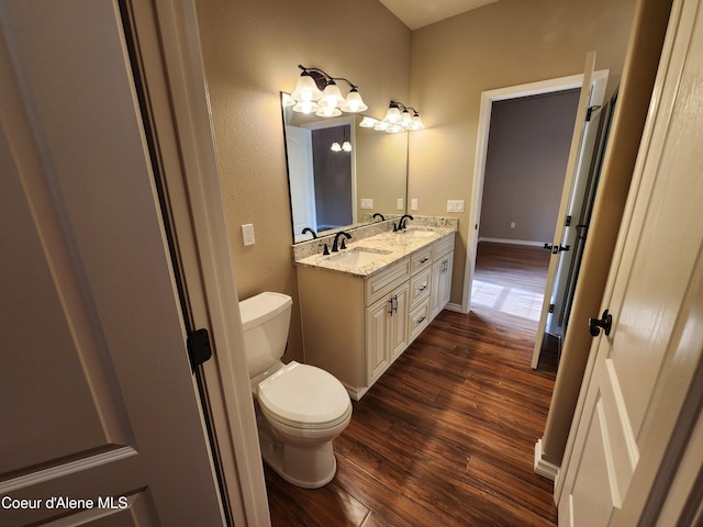 bathroom with toilet, vanity, and hardwood / wood-style flooring