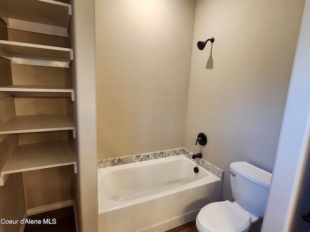 bathroom featuring a tub, wood-type flooring, and toilet