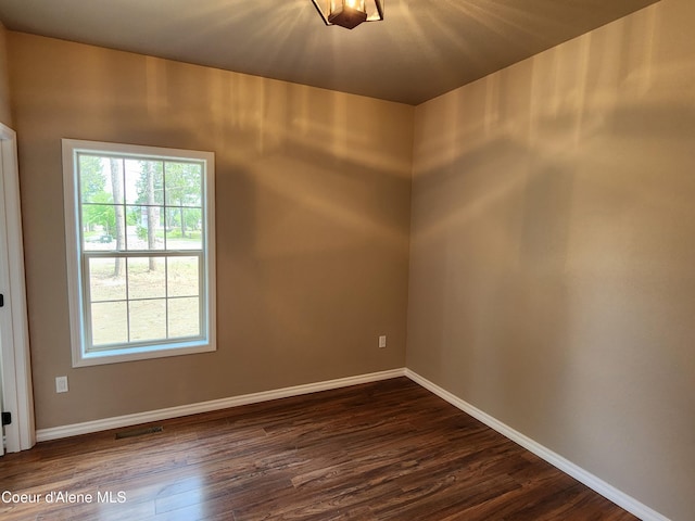 spare room with dark wood-type flooring