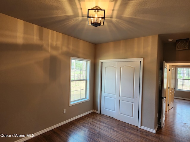 unfurnished bedroom with dark wood-type flooring and a closet