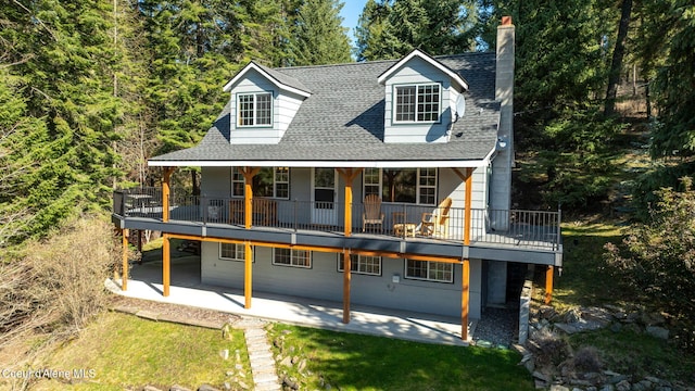 19503 E Hayden Lake Rd, Hayden, ID 83835 - exterior space with a patio, a shingled roof, and a chimney