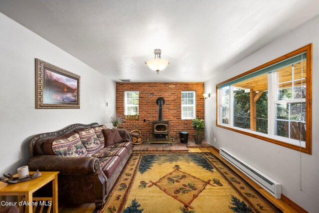 19503 E Hayden Lake Rd, Hayden, ID 83835 - living area with visible vents, wood finished floors, a wood stove, and baseboard heating