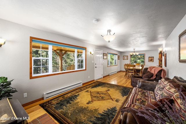 19503 E Hayden Lake Rd, Hayden, ID 83835 - living area with light wood-type flooring, a notable chandelier, and a baseboard heating unit