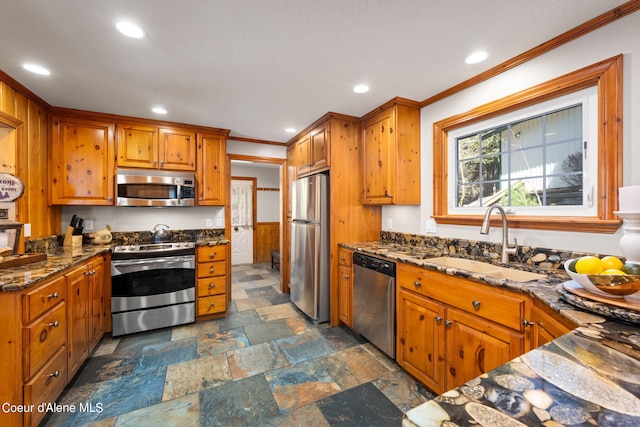 19503 E Hayden Lake Rd, Hayden, ID 83835 - kitchen with crown molding, stainless steel appliances, dark stone countertops, a sink, and stone tile floors