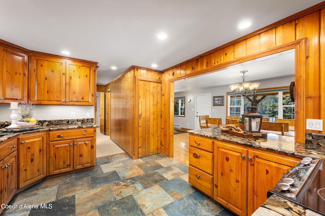 19503 E Hayden Lake Rd, Hayden, ID 83835 - kitchen with dark stone counters, stone finish floor, a chandelier, and brown cabinets