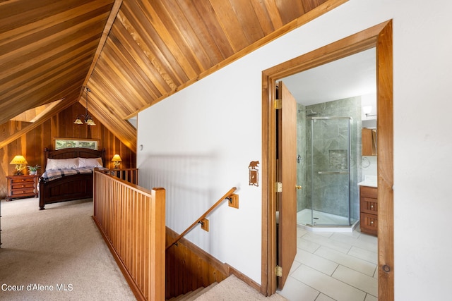 19503 E Hayden Lake Rd, Hayden, ID 83835 - bedroom with ensuite bathroom, vaulted ceiling, wooden walls, and light carpet