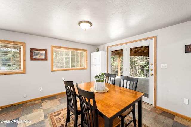 19503 E Hayden Lake Rd, Hayden, ID 83835 - dining area featuring baseboards, a textured ceiling, stone tile flooring, and a healthy amount of sunlight