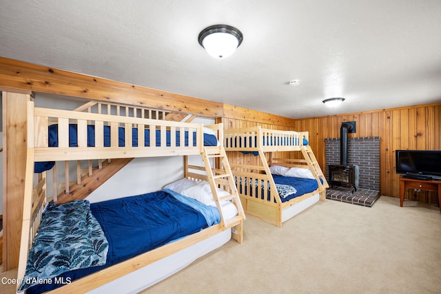 19503 E Hayden Lake Rd, Hayden, ID 83835 - bedroom featuring carpet, wooden walls, and a wood stove