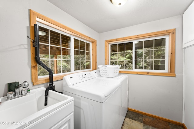 19503 E Hayden Lake Rd, Hayden, ID 83835 - washroom with stone finish floor, baseboards, laundry area, a sink, and separate washer and dryer