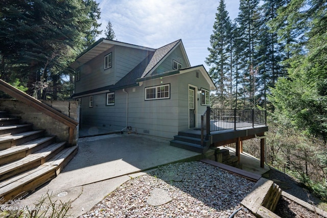 19503 E Hayden Lake Rd, Hayden, ID 83835 - rear view of house featuring a wooden deck, stairway, roof with shingles, and a patio area