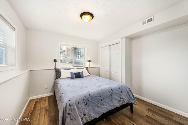 bedroom featuring dark hardwood / wood-style floors, a closet, and a textured ceiling