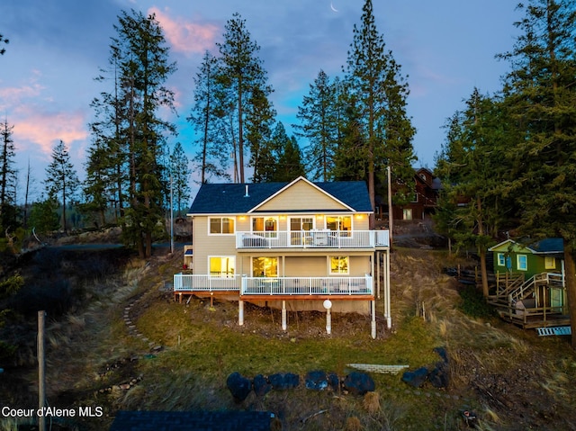 rear view of property with a deck, an outdoor structure, and a balcony