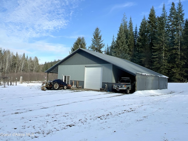 snow covered structure with a garage