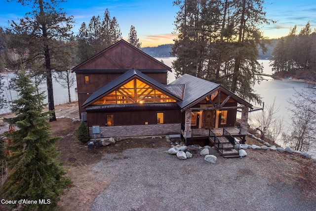 log home featuring a water view and a porch