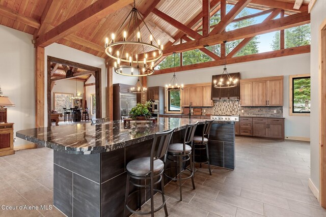 kitchen with hanging light fixtures, a breakfast bar area, dark stone counters, and a notable chandelier