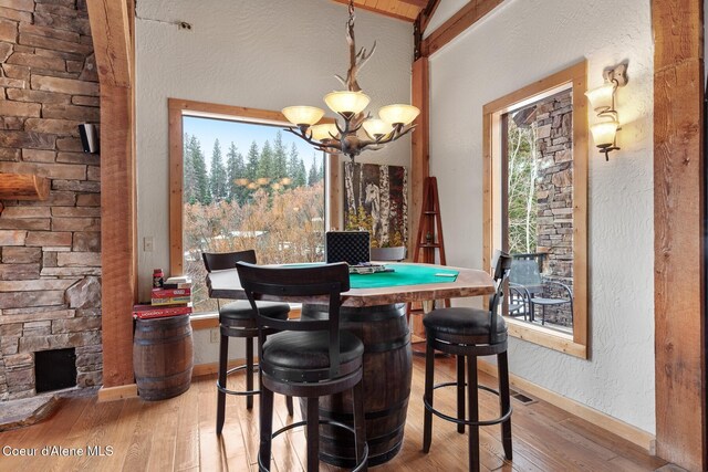 dining room with baseboards, a textured wall, light wood finished floors, and an inviting chandelier