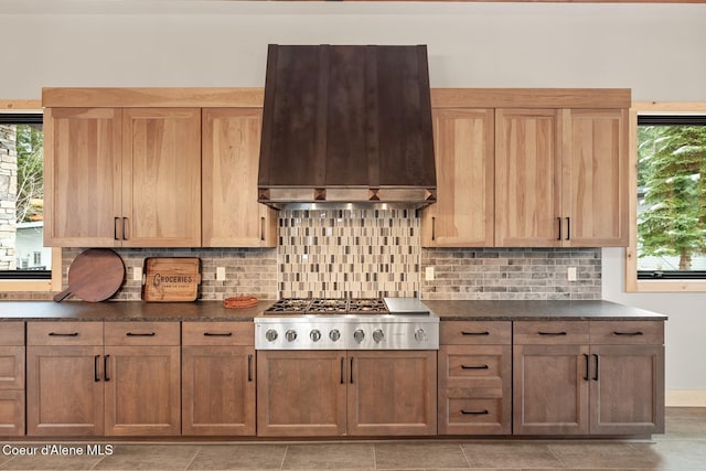 kitchen with stainless steel gas cooktop, decorative backsplash, and custom range hood