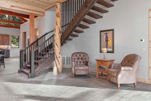 staircase featuring visible vents, beam ceiling, and baseboards