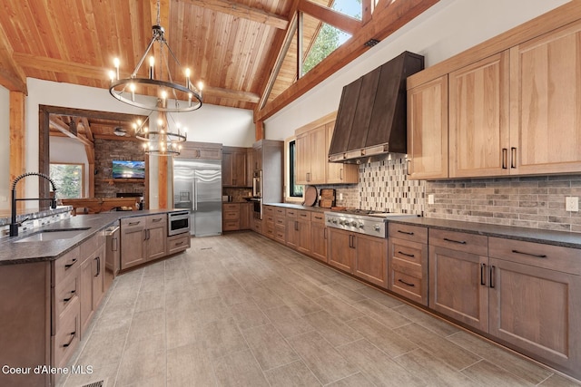 kitchen with an inviting chandelier, stainless steel appliances, premium range hood, pendant lighting, and a sink