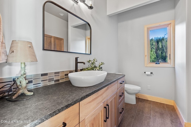 bathroom with vanity, toilet, and baseboards