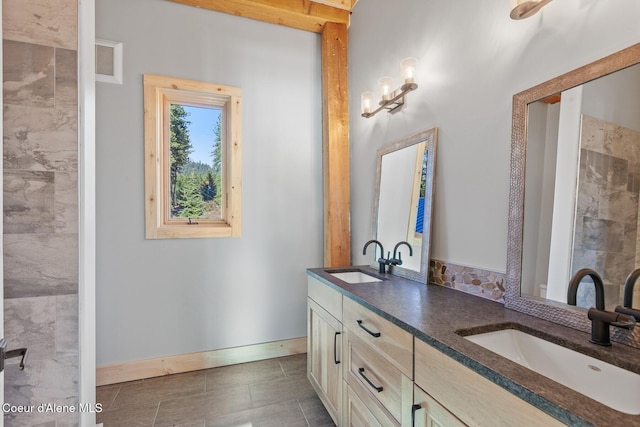 bathroom featuring double vanity, baseboards, visible vents, and a sink