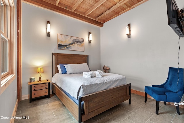 bedroom featuring vaulted ceiling with beams, wood ceiling, and baseboards