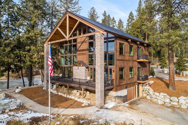 view of home's exterior featuring a garage, metal roof, and driveway