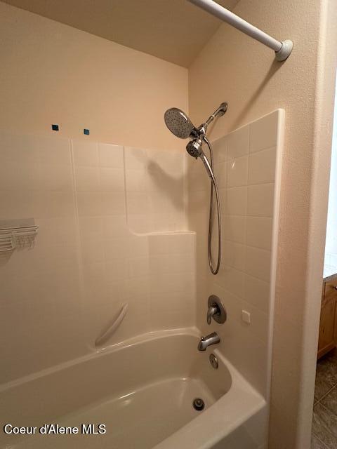 bathroom featuring washtub / shower combination and vanity