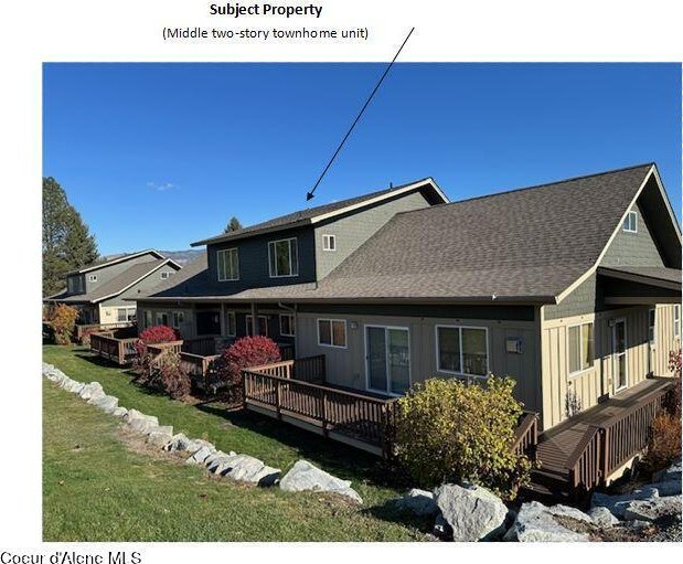 rear view of house featuring a deck and a lawn