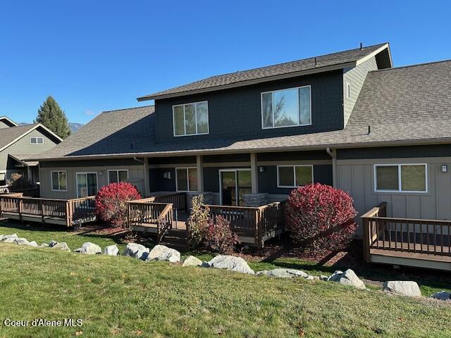 rear view of house with a wooden deck and a yard