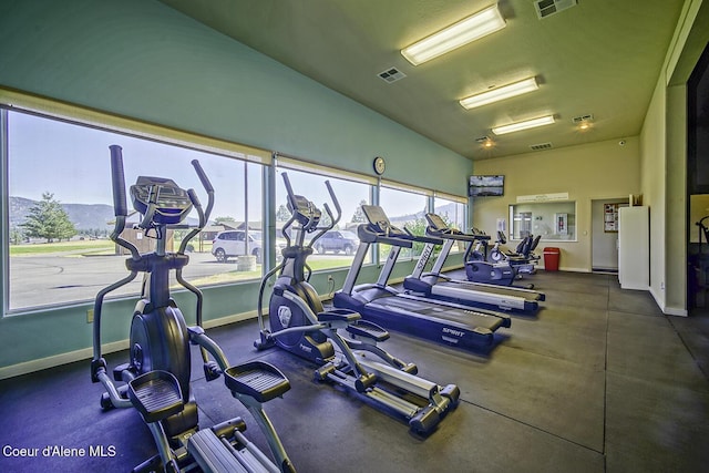 gym with a mountain view and lofted ceiling