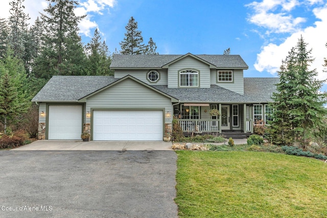 view of front property featuring a garage, a front yard, and covered porch