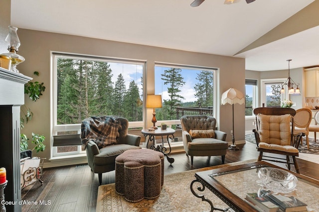 living room with ceiling fan, lofted ceiling, a wealth of natural light, and dark hardwood / wood-style flooring