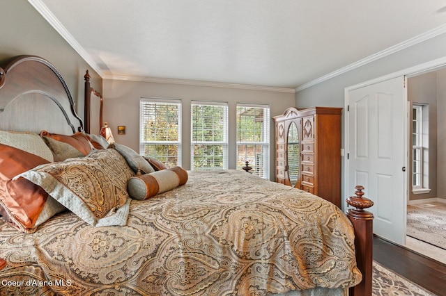 bedroom with crown molding and hardwood / wood-style floors