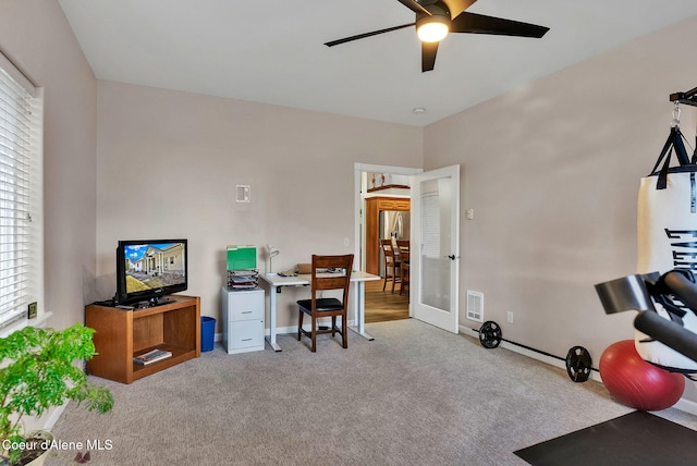 home office with light carpet and ceiling fan