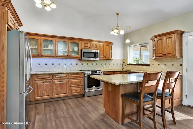 kitchen featuring decorative light fixtures, sink, dark hardwood / wood-style flooring, stainless steel appliances, and an inviting chandelier