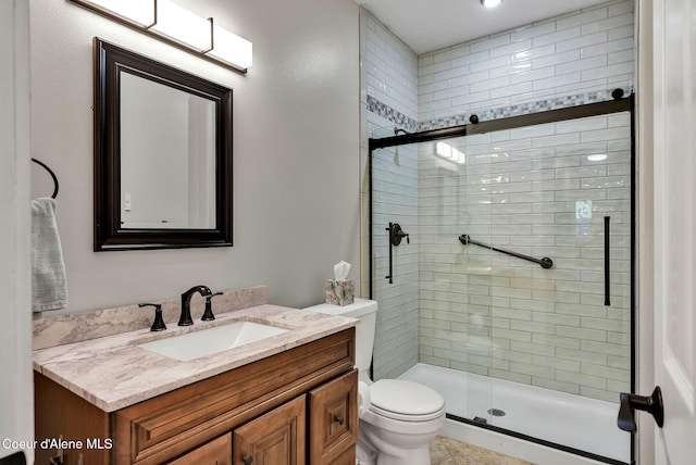 bathroom with vanity, toilet, and a shower with shower door