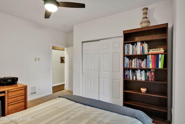 carpeted bedroom featuring ceiling fan and a closet