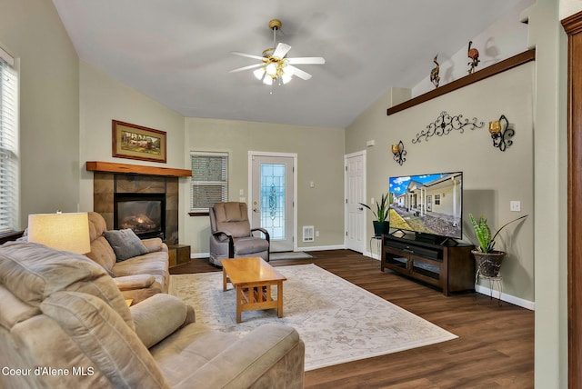 living room featuring a tile fireplace, lofted ceiling, dark hardwood / wood-style floors, and ceiling fan