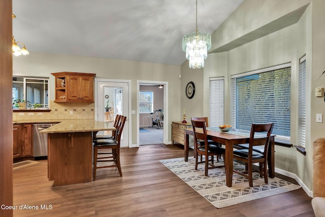 dining space featuring vaulted ceiling, dark wood-type flooring, and a chandelier