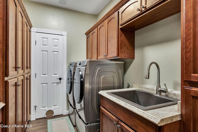 washroom featuring sink, dark hardwood / wood-style floors, cabinets, and independent washer and dryer