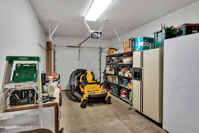 garage with a garage door opener and white refrigerator with ice dispenser