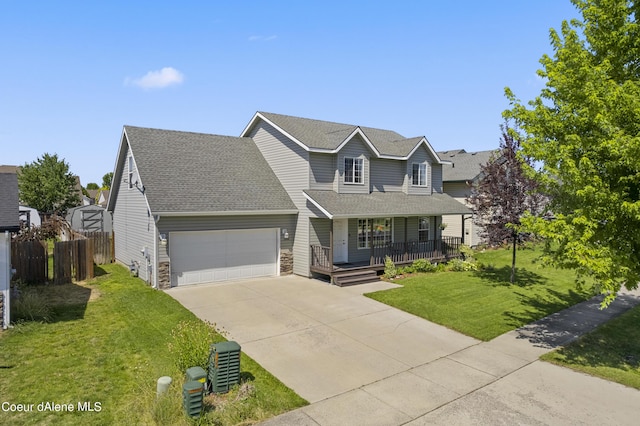 view of property featuring covered porch, a garage, and a front lawn