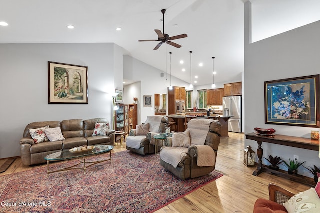 living room featuring light wood-type flooring, a ceiling fan, recessed lighting, and high vaulted ceiling