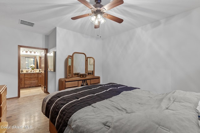 bedroom with a ceiling fan, light wood finished floors, ensuite bath, and visible vents