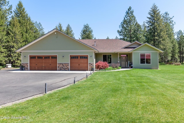 ranch-style home featuring roof with shingles, aphalt driveway, an attached garage, a front lawn, and stone siding