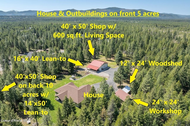 birds eye view of property featuring a view of trees and a mountain view