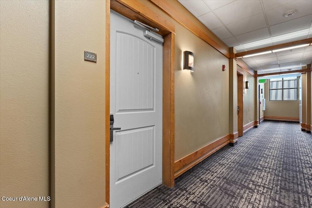 hall with a paneled ceiling