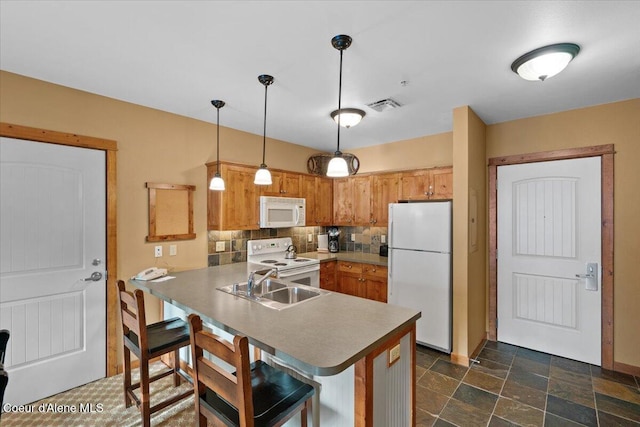 kitchen with tasteful backsplash, sink, hanging light fixtures, kitchen peninsula, and white appliances